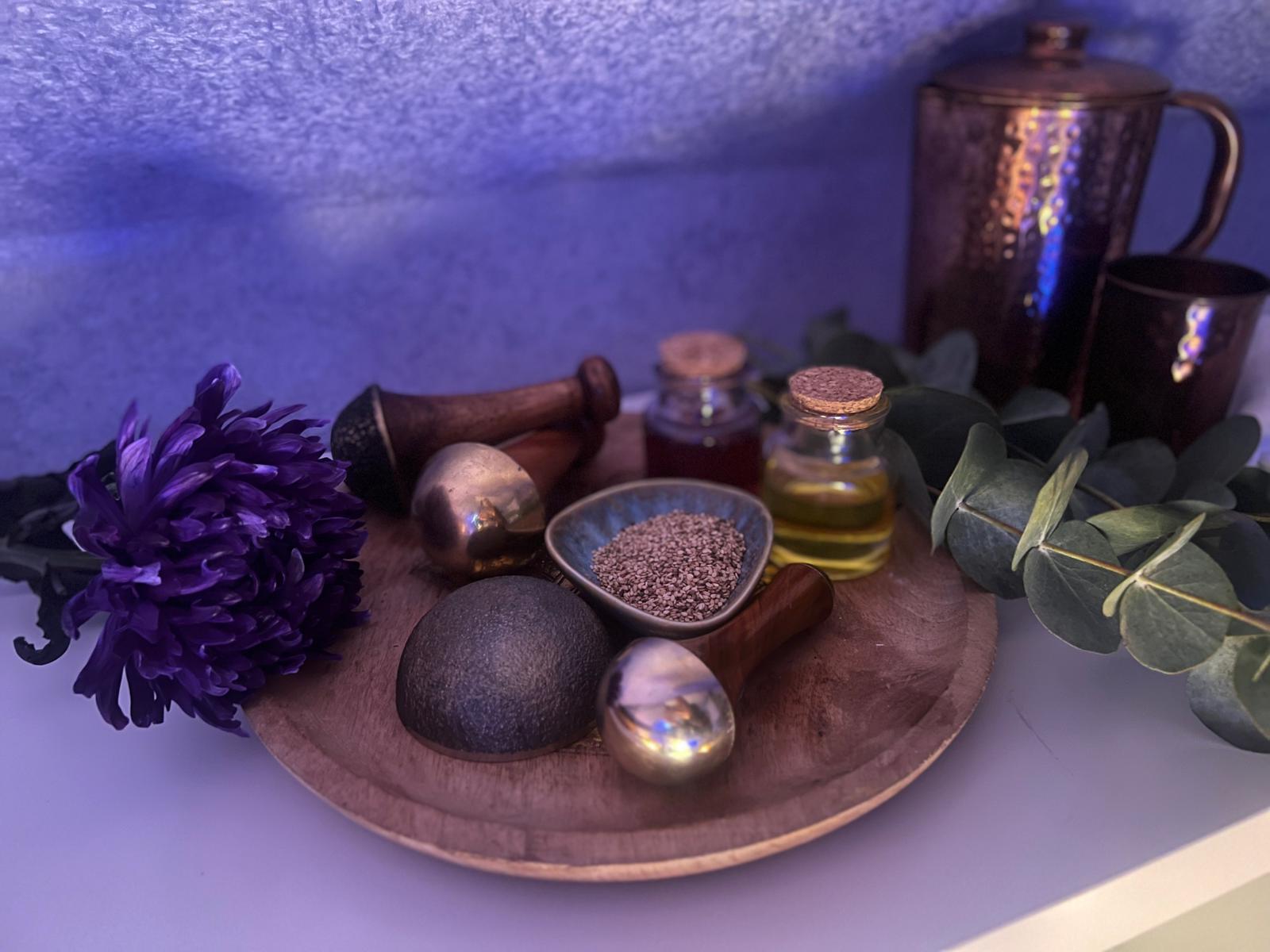 Ayurveda-Set mit Öl, Samen, Blüte und Massageutensilien