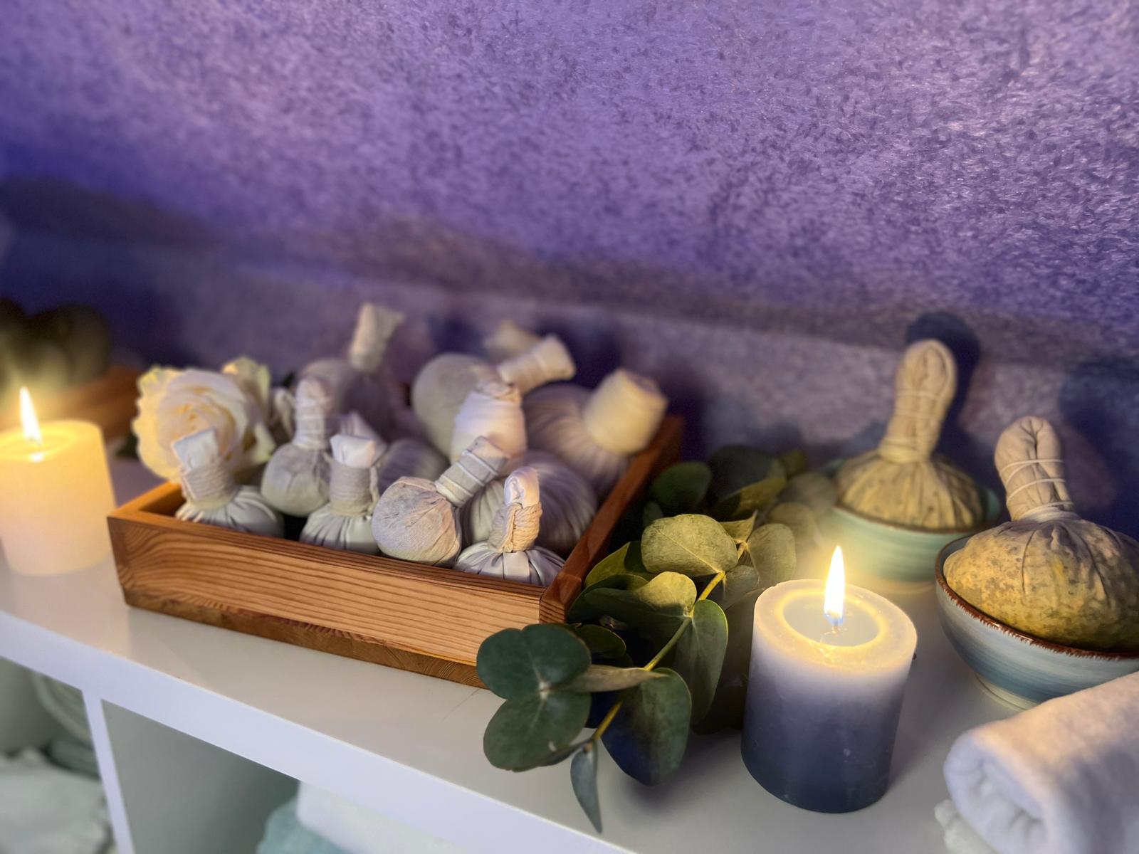 Kräuterstempel mit Kerzen und Rose im Wellnessraum